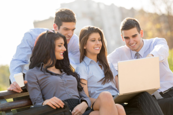 Group of young business people looking at laptop: MaxFilings Interviews & Advice Blog